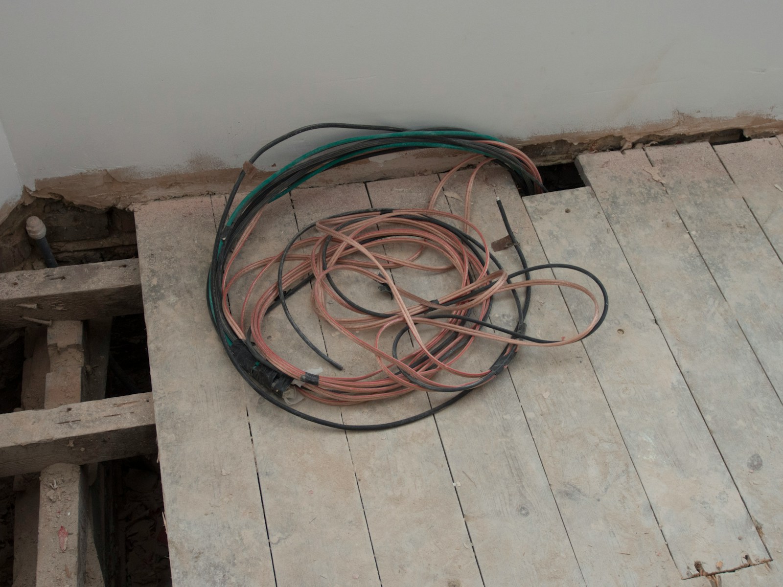 A pile of wires sitting on top of a wooden floor