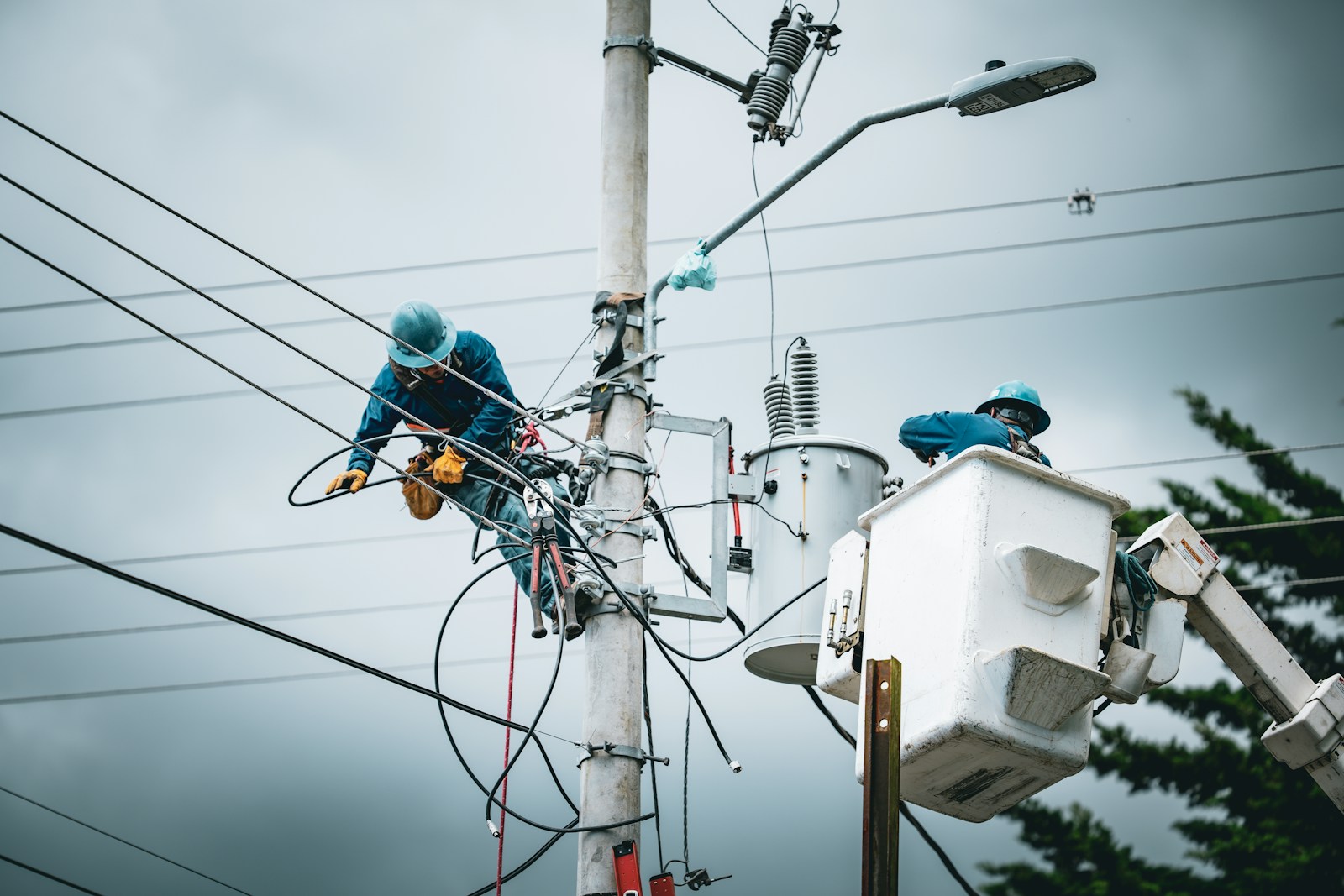 Linemen working on a utility pole with bucket truck.